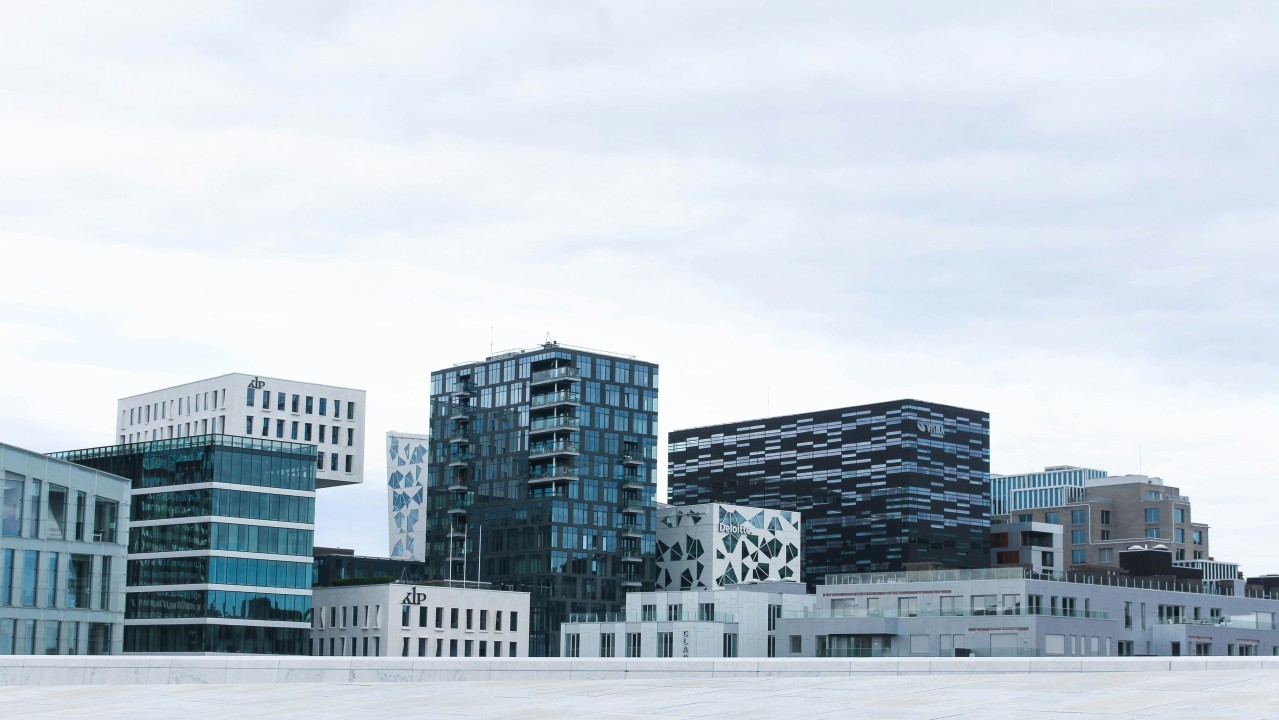 Modern city buildings under a cloudy sky.